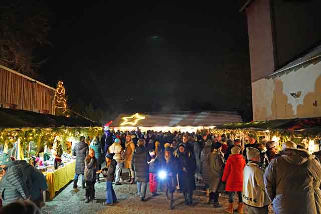 Riederauer Adventsmarkt 2024 - Blick über den gut besuchten Adventsmarkt im Dunklen