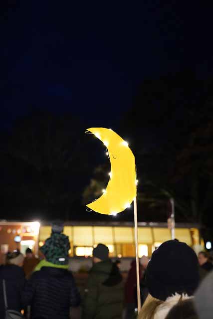 beleuchtetes Schild der Mondgruppe wird in die Luft gehalten