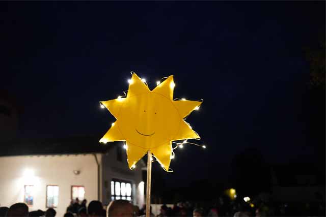 beleuchtetes Schild der Sonnengruppe wird in die Luft gehalten