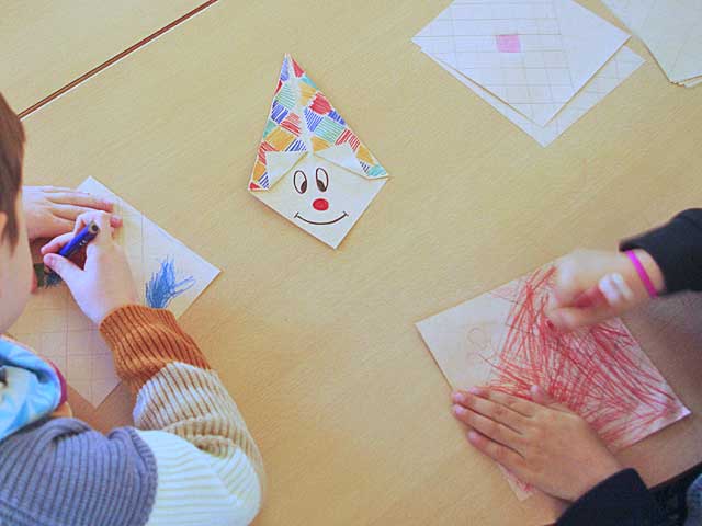 Kinder malen Clowns und falten das Papier