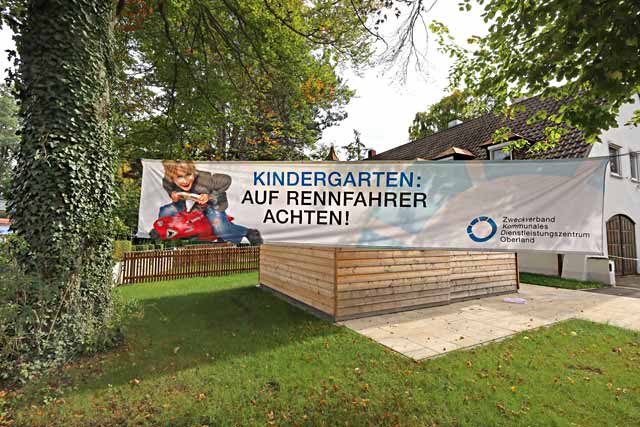 Große Transparentfahne am Ortseingan mit Warnhinweis zum KIndergarten für Autofahrer