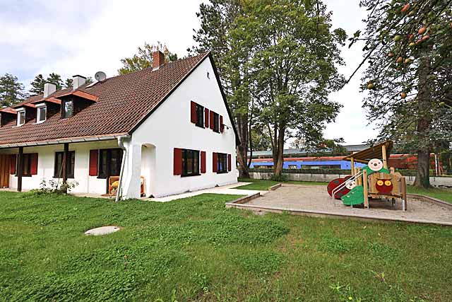 Altes Rathaus mit neuem Klettergerät und Sandkasten für die Regenbogengruppe im Garten
