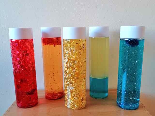 Flaschen mit verschiedenfarbigen, klitzernden Flüssigkeiten