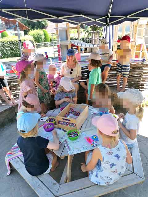 Kreatives Arbeiten mit Perlen im Garten unter einem Sonnendach