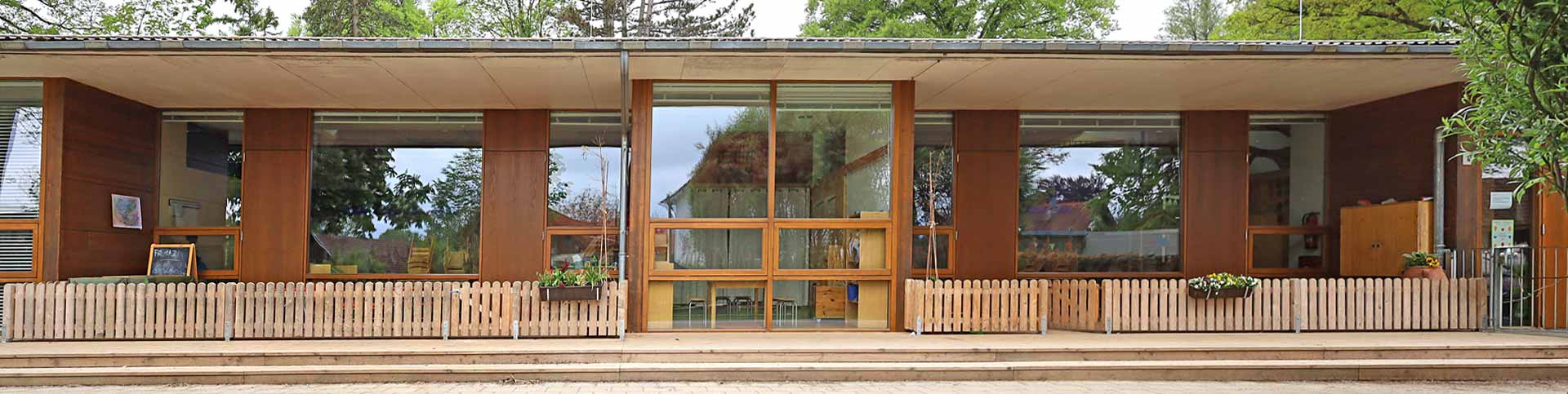 Fensterfassade mit Terrasse des Haupthauses von Garten aus 