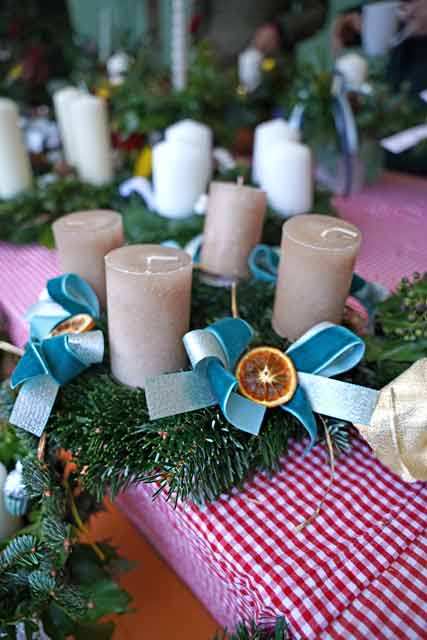 Riederauer Adventsmarkt 2024 - Ein Advenmtskranz mit beigen Kerzen und hellblauen Schleifen