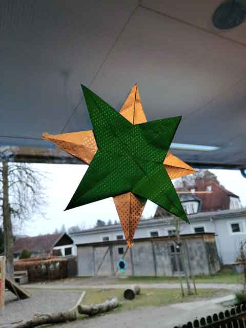 Wir bastekn Weihnachssterne - ein großer Stern hängt im Gruppenraum