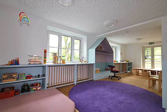 Gruppenraum der Regenbogen-Gruppe im alten Rathaus von Riederau mit lilafarbenen Teppichen