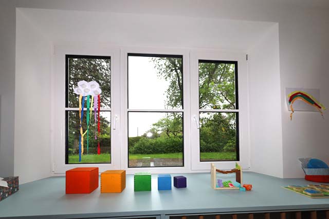 Spielzeug auf dem Fenstersims im Gruppenraum, Blick in den Garten